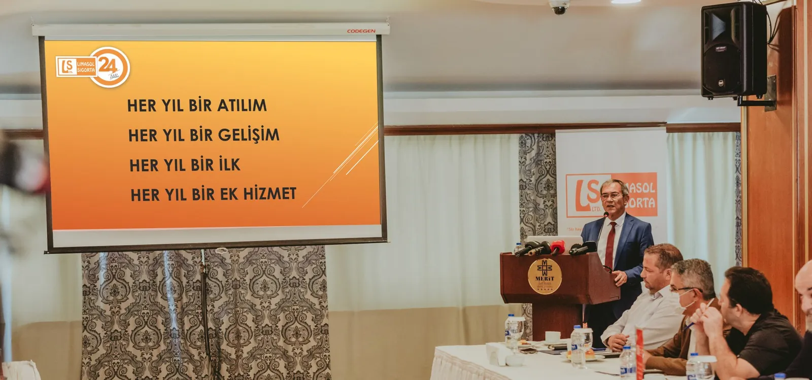 Basın toplantısında masa başında yöneticiler ve gazeteciler